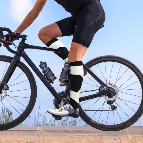 High Performance Unisex Athletic Compression Socks Featuring Graded Ankle Support Breathable Moisture Wicking Fabric Black White Piano Plate Grid Design on cyclist's legs.