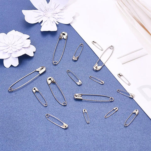 450 Pack Real Deal Iron Safety Clasp Pins For Crafting And Tailoring displayed on blue background with paper flowers.