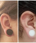 Close-up of 22mm Black and White Silicone Ear Gauges Tunnels Plugs Set Of 3 Pairs In White And Flesh Colors worn in ears