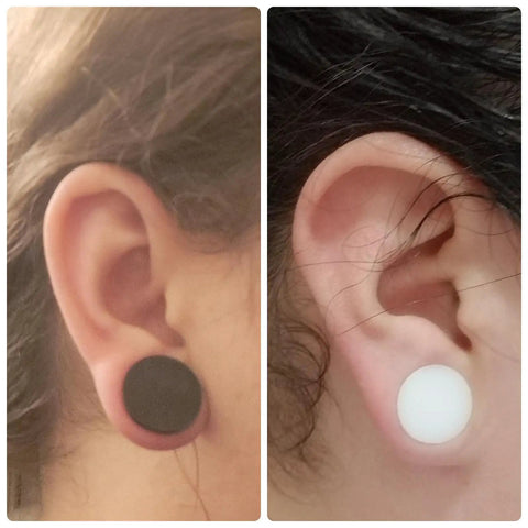 Close-up of 22mm Black and White Silicone Ear Gauges Tunnels Plugs Set Of 3 Pairs In White And Flesh Colors worn in ears