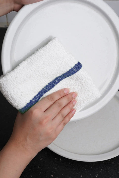 Hand using 16x19 inch terry cloth rag to clean plate; part of Value Pack Of 36 Absorbent 16x19 Inch Terry Cloth Cleaning Rags For Home And Business.