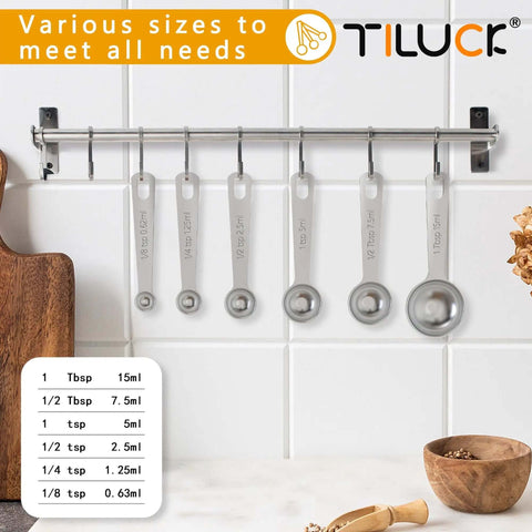 Six Piece Stainless Steel Measuring Spoons Set For Cooking And Baking displayed on a kitchen wall rack