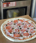 Heavy Duty PTFE Dehydrator Sheets 14 Inch Nonstick Baking Mats And Oven Liners For BBQ Hot Plate with uncooked pizza.
