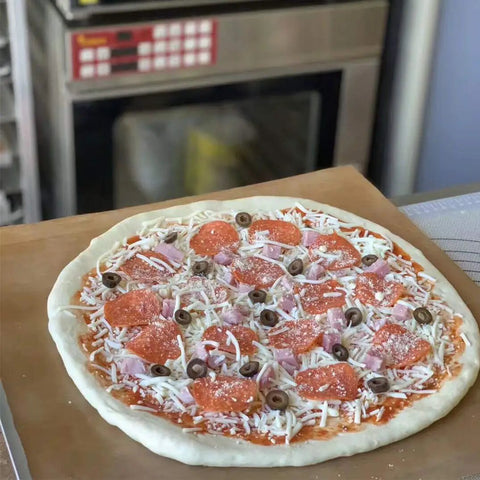 Heavy Duty PTFE Dehydrator Sheets 14 Inch Nonstick Baking Mats And Oven Liners For BBQ Hot Plate with uncooked pizza.