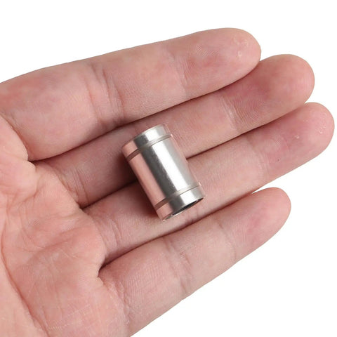 LM8UU 12 Piece Linear Ball Bearings 8mm Bore With Double Sided Rubber Seals shown in hand for size comparison