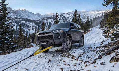 SUV using 3 Inch Wide 8 Foot Tree Saver Strap With Loops Heavy Duty Winch And Recovery Tow Strap 30000 Lbs MBS in snowy mountains