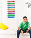 Boy sitting on couch with Set Of 9 Rainbow Themed Wood Wall Plaques For Boys Room With Inspirational Quotes Hanging Signs visible