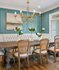 Gold Farmhouse Chandelier With Six Candle Style Lights above dining table, antique brass finish for a vintage vibe