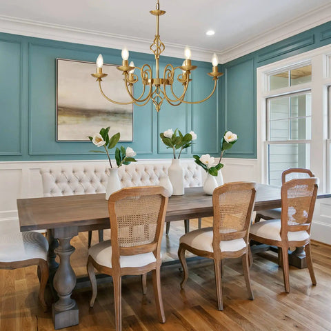 Gold Farmhouse Chandelier With Six Candle Style Lights above dining table, antique brass finish for a vintage vibe