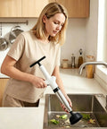 Clear Out Messy Blockages No Sweat With This Rechargeable Electric Plunger Built For Toilets Sinks And Floor Drains Plus An Ergonomic Grip That Makes Heavy Duty Work Smooth in woman’s hand over kitchen sink.