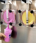 Commercial Dual Tank Ice Slush Machine For Top Shelf Margaritas And Creamy Milkshakes With Smart Freeze Tech pouring pink slush.