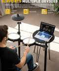 Man playing Electric Drum Set With USB MIDI Dual Power Modes Dual Zone Triggering 64 Polyphony 225 Authentic Sounds with laptop