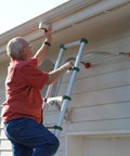Man uses Heavy Duty Ladder Stabilizer for safer roof access and gutter protection. Fits most ladders, 19 inch safe work area.