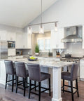 Three Light Modern Chandeliers For Kitchen Island Lighting In Brushed Nickel With Clear Glass Pendants Adjustable Height Linear Ceiling Mount Perfect For Dining Room Farmhouse Vibe over a kitchen island with gray chairs.