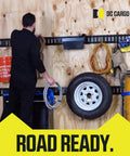 Man organizing trailer with DC Cargo gear for road readiness and transport security