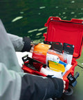 Mini Pro Waterproof First Aid Kit For Car, Home, Boat, Camping And Travel opened showing medical supplies on a dock