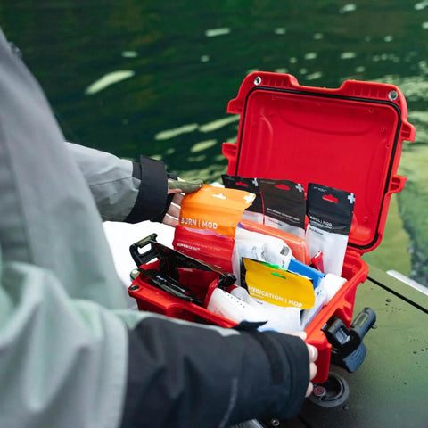 Mini Pro Waterproof First Aid Kit For Car, Home, Boat, Camping And Travel opened showing medical supplies on a dock