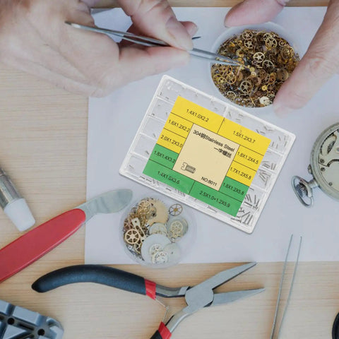 Hands using tweezers to pick watch repair screws from a kit, showcasing the Essential Stainless Steel Watch Repair Screw Set Including Ten Individual Micro Screw Varieties For Case Back Strap Links And Clasp Maintenance Gear Built For Rapid Timepiece Adjustments And Keeping Your Pro Workbench Fully Loaded.