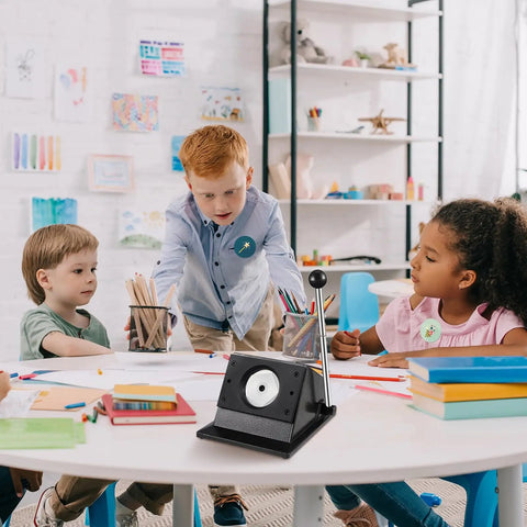 Children gathered around a table with a 58mm Button Maker Circle Cutter Punch For Badges And DIY Crafts, sturdy metal base visible.