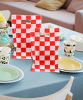 Race Car Themed Gift Bags With Handle Pack Of 50 Portable Lightweight Plastic Candy Bags on a table setting, checkered pattern.