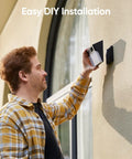 Person installing All In One Solar Wall Light Camera With 8GB Storage For Outdoor Security on wall, easy DIY installation.