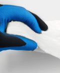Ceramic fiber blanket insulation, white, held by blue-black gloved hand.