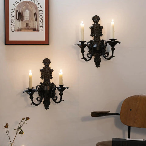 Premium Black And Gold Metal Candle Sconces Set Of Two, Gothic Wall Decor For Living Room, Rustic Iron Candle Holders, Dark Academia Vibes, Dope Home Accent Pieces That Slap, showcased on a wall with two lit taper candles.