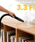Hand using the Straight Up Powerhouse Lightweight Cordless Handheld Vacuum with a 3.3 ft extension on wooden shelf.