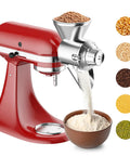 Metal grain mill attachment for KitchenAid stand mixer; red mixer shown with stainless steel grinding head.