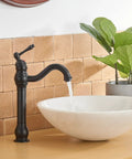 Matte Black Vessel Sink Faucet With 360 Degree Swivel next to white round basin in bathroom setting