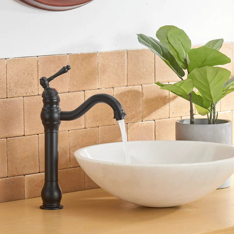 Matte Black Vessel Sink Faucet With 360 Degree Swivel next to white round basin in bathroom setting