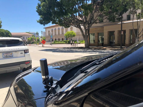 Dual Band GMRS NMO Mount Antenna for VHF 136-174 MHz and UHF 400-470 MHz, mounted on vehicle in urban setting