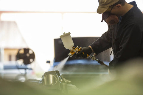 Heavy Duty Forged Spray Gun With 1.3 Mm Tip And Stainless Needle Featuring Air Curtain Design in use, delivering smooth paint finish.