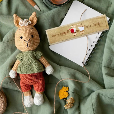 Wooden Pregnancy Keepsake Box For Dad And Hubby With Engraved Feet And Hearts Push Pull Baby Announcement Gift Raffia Ribbon Perfect Pregnancy Reveal Keepsake 8 By 2 By 1.2 Inches, on notebook beside crocheted doll