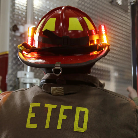 Firefighter wearing Helmet Strap Mount Accessory With Two Magnetic Mounts And Screw In Feature For Hard Hats And Fire Safety Helmets