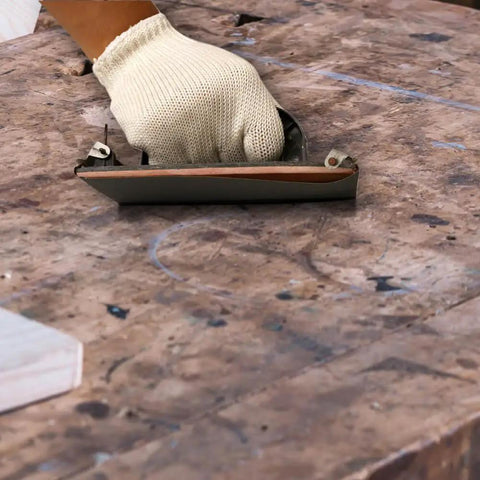 Hand using Wet Dry Sandpaper Set 42 Sheets 9 By 3.6 Inch Grit Range 120 Through 3000 Assorted Paper on wooden surface
