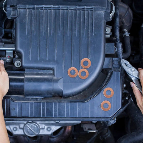 Copper Crush Sealing Washers Kit 200 Pieces Flat Ring Gaskets visible on an engine for automotive plug repair.
