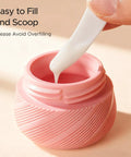 Close-up of a pink jar being filled from the 23 Pack TSA Approved Travel Bottles Set With Leakproof Refillable Silicone Squeezable Bottles And Jars