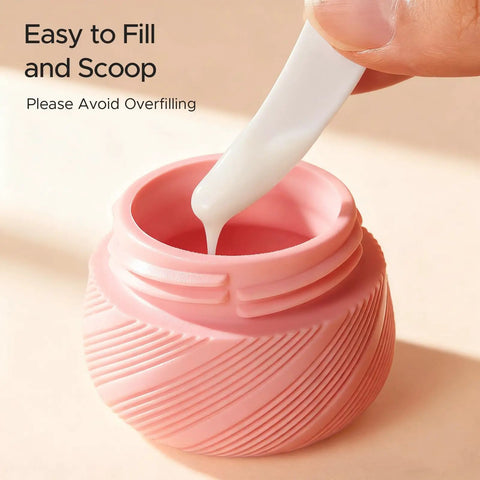 Close-up of a pink jar being filled from the 23 Pack TSA Approved Travel Bottles Set With Leakproof Refillable Silicone Squeezable Bottles And Jars