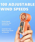 Close-up of orange Beast Portable Handheld Fan On The Go With USB-C Rechargeable Battery, 100 Speed Adjustable, digital display visible.