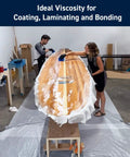 Two people applying 5 To 1 Marine Epoxy Resin Kit For Bonding, Coating, Filleting, And Laminating For Fiberglass, Wood, And Carbon Fiber Projects on a surfboard