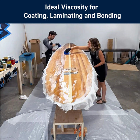 Two people applying 5 To 1 Marine Epoxy Resin Kit For Bonding, Coating, Filleting, And Laminating For Fiberglass, Wood, And Carbon Fiber Projects on a surfboard