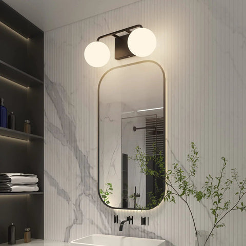 Two Light Mid Century Vanity Lights Over Mirror Matte Black With Milk White Glass Globes, installed in modern bathroom.