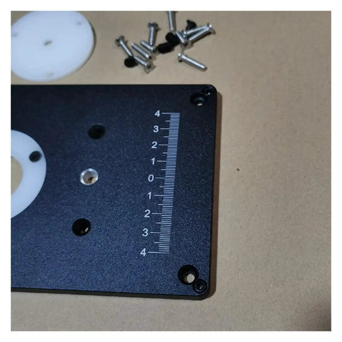Close-up of Top Shelf Aluminum Router Table Insert Plate With Reliable Woodworking Mounts, measuring scale, and screws.