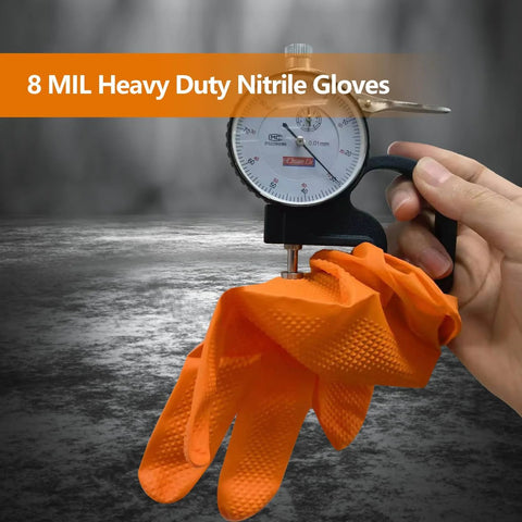 Front view of orange 8-mil nitrile disposable gloves with raised diamond texture, held around a dial gauge.