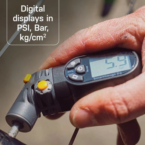 Hand holding Digital Tire Pressure Gauge With Dual Valve SmartHead For Presta And Schrader, clear LCD readout 5.4 PSI.