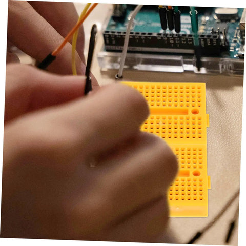 Plug And Play Solderless Breadboard Kit With Six Compact Yellow Protoboard Panels For Rapid Circuit Assembly and Hassle Free Electronics Crafting For Tech Students And Weekend Builders with jumper wires connected.