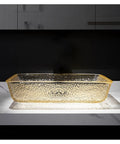 Go Big Or Go Home Bathroom Remodel With This Premium Crystal Glass Vessel Basin Featuring Tough Rectangular Design Heavy Duty Construction Smooth Pop Up Drain And Shatter Proof Build That Seriously Slaps - Gold rectangular vessel sink on countertop.