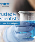 Gloved hand holding a Pyrex glass beaker with blue liquid, emphasizing laboratory precision and trust by scientists.