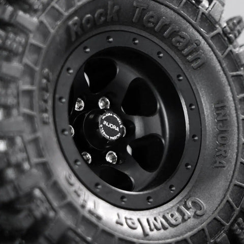 Close-up of a black M2 Wheel Lock Nut With CNC Aluminum Cap on a 1/24 RC crawler tire, showing detailed cap and wheel texture